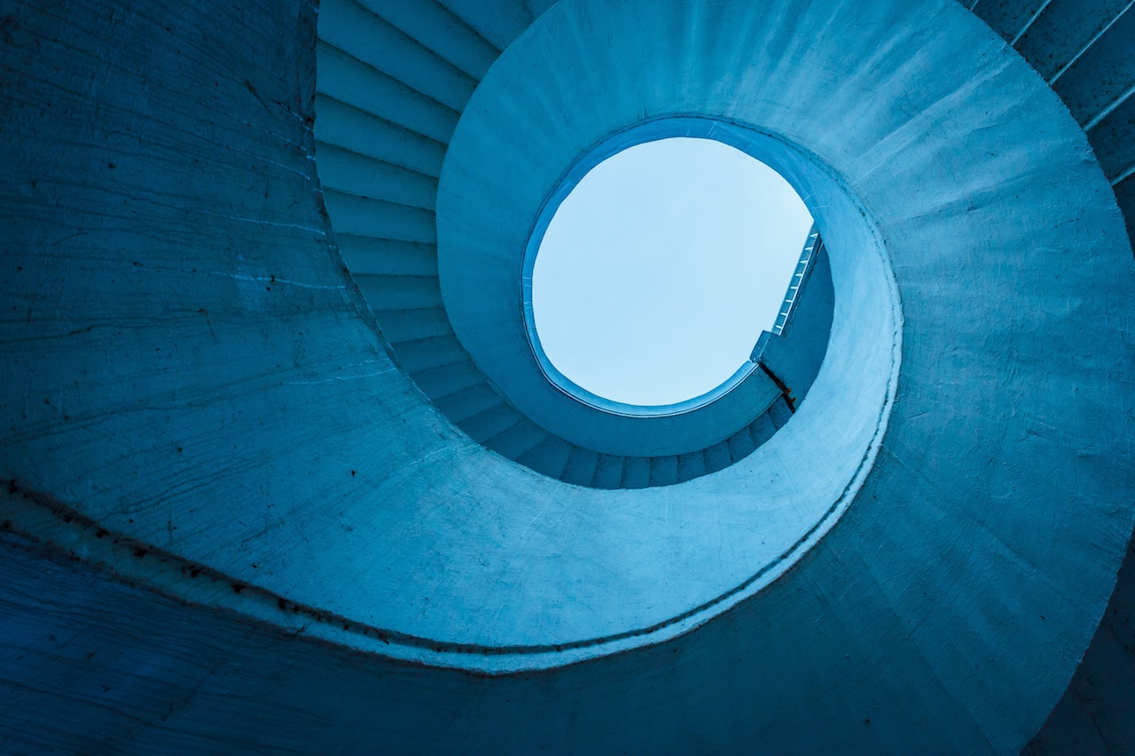 Photograph of a blue spiral staircase from below
